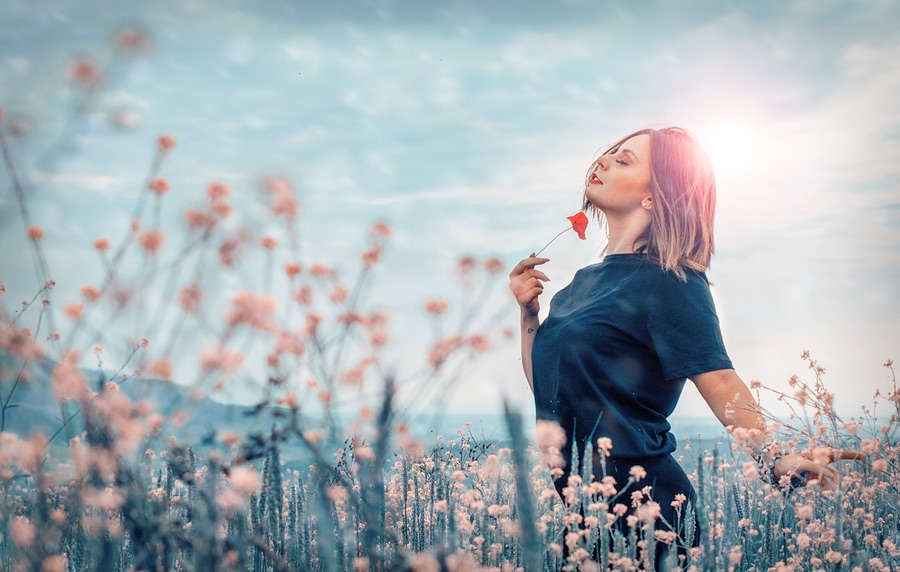 Woman walking thru a field of flowers